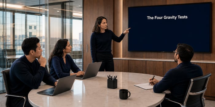 Cloud architect pointing at a wall screen titled The Four Gravity Tests, the framework for choosing between AWS, Azure and GCP at a mid-market company